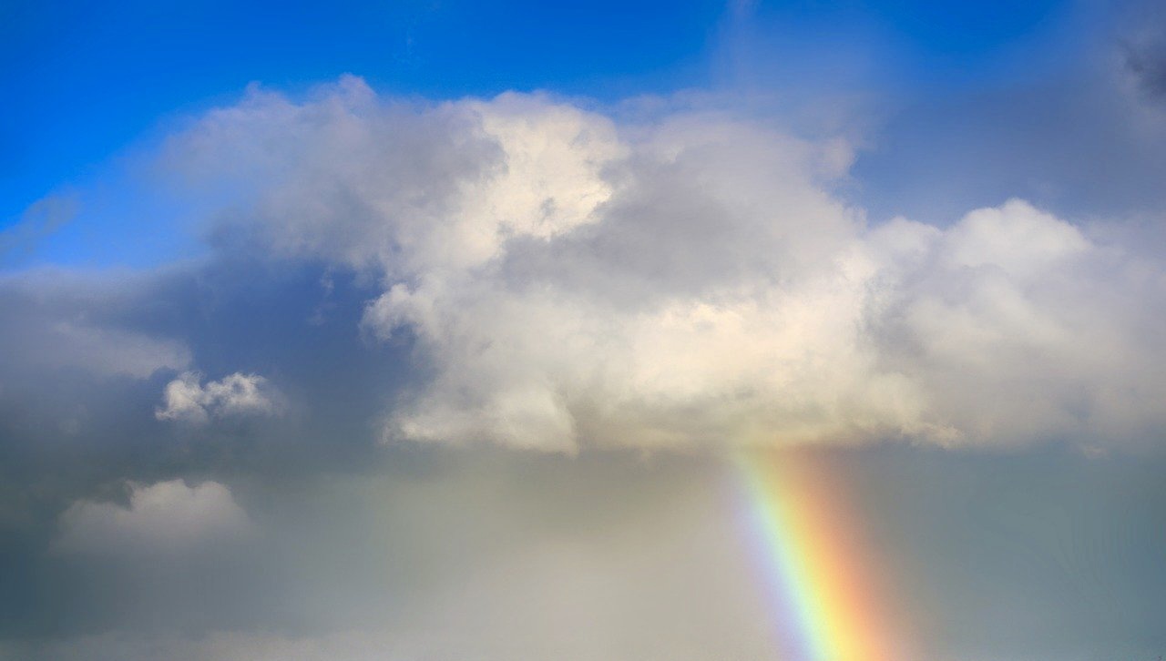A rainbow breaking through clouds after a storm